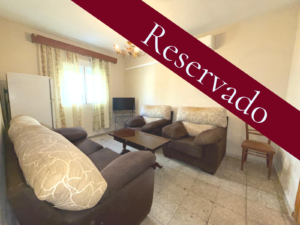 en la imagen se ve la foto del salon de la vivienda con el banner de reservado